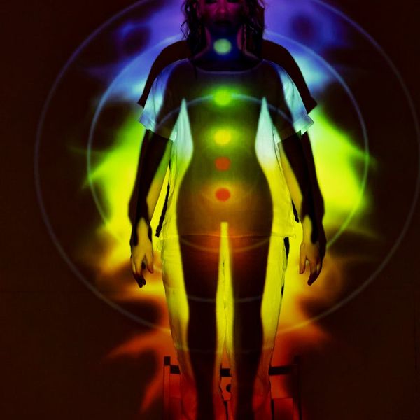 Abstract silhouette of a person in a meditative state with saffron-colored light.